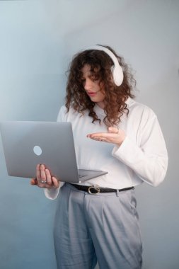 Laptop ve kulaklıklı rahat kıyafetler giyen öğrenci, uzaktan öğrenme esnekliğini gösteren video çağrısı yoluyla çevrimiçi sınava giriyor.