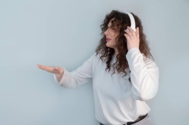 Kıvırcık saçlı tutkulu DJ, kablosuz kulaklık takıyor, şarkı söyleyip dans ederken yeni bir parça yaratıyor..