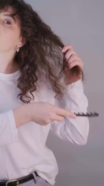 Sabah saç bakımı rutini: bukleleri fırçalamak ve kafa masajı yapmak ve sağlıklı saçlar için gülümsemek. Yüksek kalite 4k görüntü