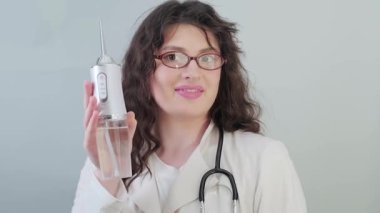 Elektrikli sulayıcı, profesyonellerin seçimi: dişçi, diş hekiminin ağız sağlığı için nasıl etkili kullanılacağı konusunda ipuçları paylaşıyor. Yüksek kalite 4k görüntü