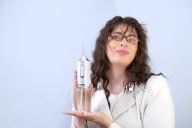 Kadın diş hekimi, diş çürükleri ve diş eti hastalıklarını önleyerek bir sulayıcının diş sağlığını nasıl iyileştirdiğini ayrıntılı olarak açıklıyor..