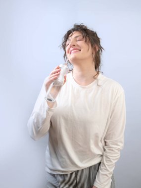 Bir kadın dişlerini bir sulayıcıyla temizler, ağız sağlığıyla ilgilenir ve dişçisinin tavsiyesine uyar..