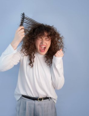 Kıvırcık saçlı her insan bilir ki acı çeken kadın, gerçek hayattaki saç mücadelesi anındaki karmaşık kilitleri tararken yüzünü buruşturur.