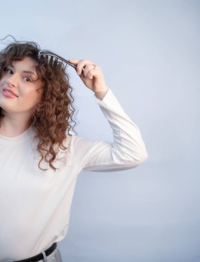 Saç bakım aksesuarı yumuşak kıllarla rahat bir fırça. Kadın saç büyümesini ve sağlığını canlandırmak için kafa masajı fırçası kullanıyor.