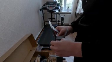 Evdeki spor aletlerini monte eden adam evde spor yapmak ve spor yapmak için rahat bir yer yaratıyor. Yüksek kalite 4k görüntü