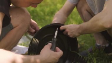 Arkadaşlar, açık hava yemekleri sırasında çevreyi korumak için yangın güvenlik kurallarını takiben barbeküye hazırlanıyorlar. Yüksek kalite 4k görüntü