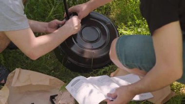 Arkadaşlar, güvenli bir açık hava barbeküsü için yangın güvenliği kurallarına uyarak koruyucu bir tezgah kurdular. Yüksek kalite 4k görüntü