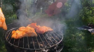 Mangal yapmak için ızgaraya çiğ biftek koyan ilk kişi doğa ızgarasında gevşetici yemek pişirir. Yüksek kalite 4k görüntü