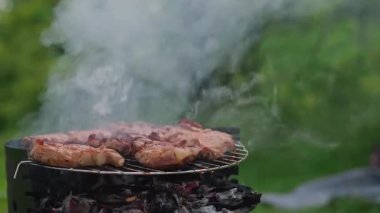 Dışarıda lezzetli biftekler akşam yemeği için barbeküde yavaşça ızgara yapıyor. Yüksek kalite 4k görüntü