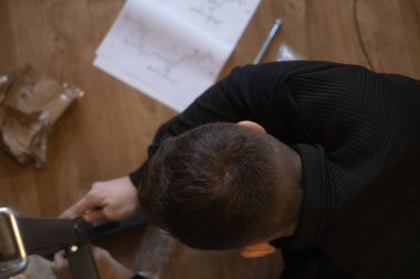 Evdeki mobilyaları monte eden adam, yaşam alanında rahatlık ve düzen yaratıyor..