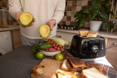 Kız ekmek kızartma makinesini açıyor, ekmek dilimlerini aşağı bastırıyor, mutfak sahnesinden yavaşça aşağı iniyor..