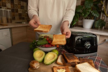 Samimi bir mutfakta sabah, bir tost makinesiyle sağlıklı bir kahvaltı hazırlar. Güne basit bir ev konforuyla başlarız..