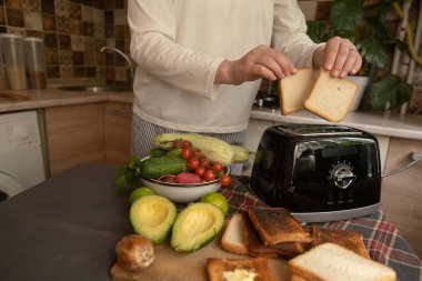 Aksiyon halindeki elektrikli aletler sabah rutinine başlamak için uygun bir tost makinesi kullanarak kahvaltıya kadeh kaldırıyor..