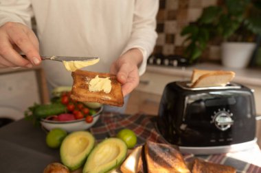 Kadınlar hızlı kahvaltı hazırlamak için tost makinesi kullanıyor. Basitlik ve kolaylık üzerine odaklanmış modern minimalist mutfak rutini..