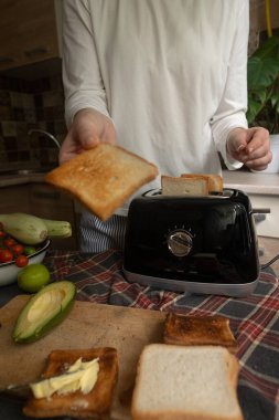 Evdeki sıcak kahvaltı ekmeği tost makinesinde kızartıyor. Mükemmel bir sabah yemeği için hızlı ve kolay bir işlem..