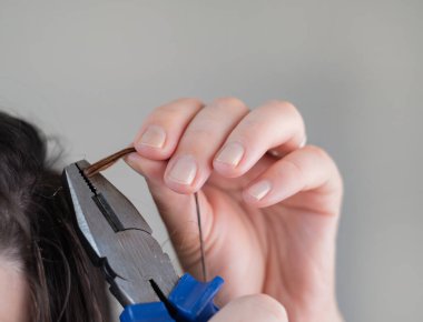 Yetenekli kuaför tarafından profesyonel kuaför salonu prosedürünün kaldırılması için saç uzatma kapsüllerinin yumuşatılması