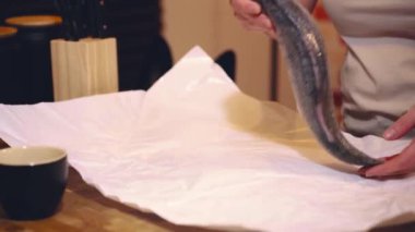 Kız mutfakta balık pişiriyor.