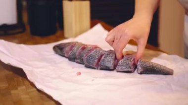 Kız mutfakta balık pişiriyor.