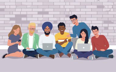 Farklı geçmişleri olan insanlar dizüstü bilgisayarları ve tuğla bir duvarın önünde telefonla oturuyorlar. Takım çalışması, modern yaşam tarzı
