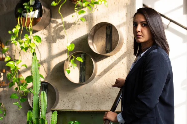 Zarif elbiseli ve gururlu ifadeli genç Arap girişimci, modern serasının içinde. Ekolojik ve ekolojik sürdürülebilir alandaki yenilik kavramı