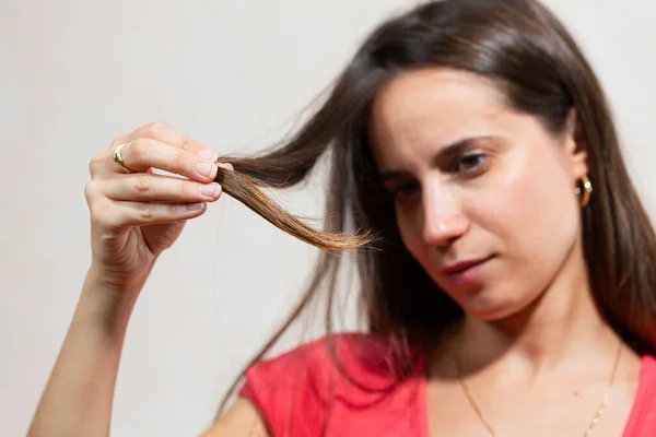 髪の毛の端を見ている女性 ロックに焦点を当て フォーカスから顔を向ける 乾燥した髪の問題 — ストック写真