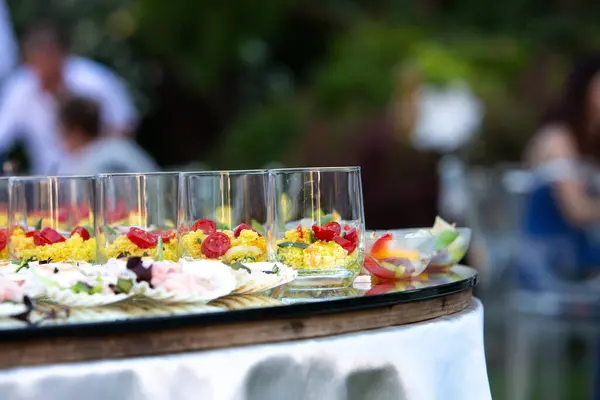 stock image Colorful wedding appetizers arranged on a glass table, adding a festive touch to an outdoor reception event