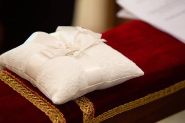 Nikah töreninde iki alyans beyaz dantel bir yastığın üzerinde duruyor.