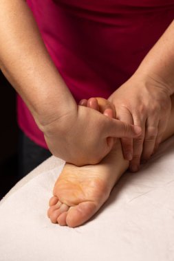 Rahatlatıcı masaj terapisi seansında ayak masajı yapan bir masöz.
