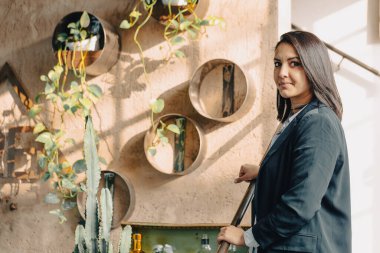 İş kadını, duvarında bitkilerle modern bir ofiste merdivenlerden yukarı çıkıyor.