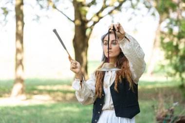 Sokak sanatçısı parkta antik bir Tibet çanı çalıyor, rahatlatıcı bir atmosfer yaratıyor.