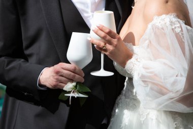 Gelin ve damat düğün kıyafetlerini giyerken iki gözlük tutuyorlar.
