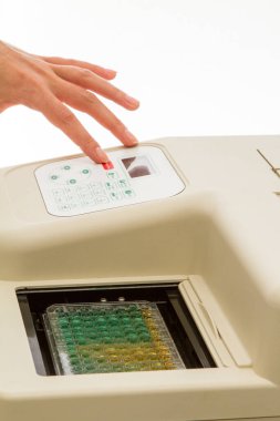 Scientist operating elisa microplate reader, analyzing samples in a 96-well microplate for medical or scientific research clipart