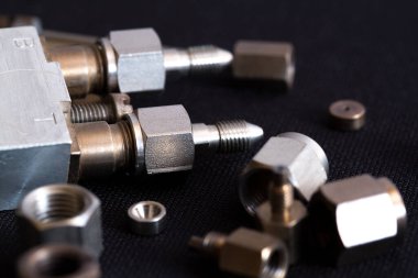 Koyu arkaplanda uzanan hidrolik sistemler için parlak metal montajlar ve bağlayıcılar