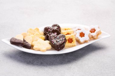 Çikolatalı, reçelli ve beyaz tabakta duran nefis ev yapımı Noel kurabiyeleri.