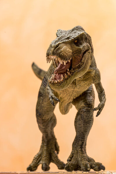 Plastic tyrannosaurus rex toy roaring ferociously on a neutral background