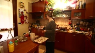 Bir kadın mutfakta yemek pişirirken Noel hazırlıkları tam gaz devam ediyor.