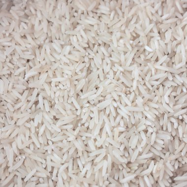 Sayısız uzun tahıllı beyaz pirincin yakın plan görüntüsü, besinlerle ilgili görseller için detaylı bir arka plan oluşturur.