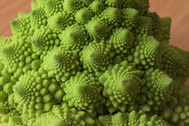 Romanesco brokoli kafasının yakın plan çekimi, karmaşık fraktal desenlerini ve canlı yeşil rengini vurguluyor.