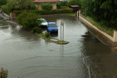 Şiddetli yağmurdan sonra taşkın sularına gömülen arabalar, aşırı havanın etkisini vurguluyor.
