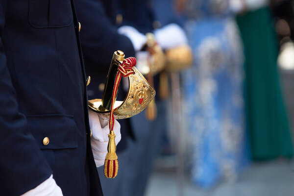 Офицер полиции держит церемониальный меч во время официального мероприятия
