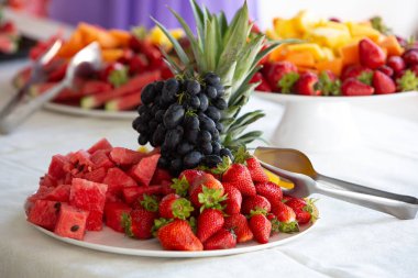 Lezzetli bir meyve tabağı, ananas, üzüm, çilek ve karpuz.