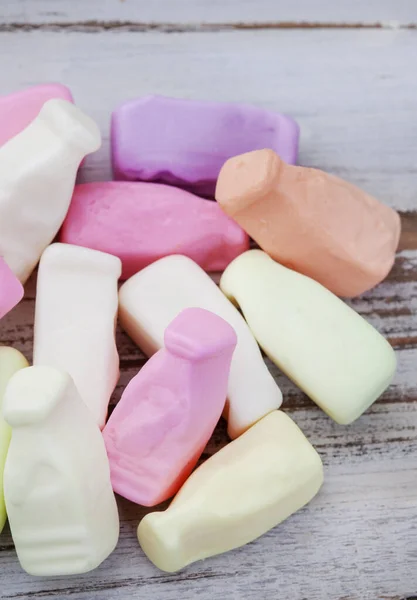 Colorful old school candy, milk bottle gummies on rustic wooden surface. A favorite through the ages