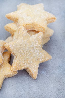 Seçici odaklı yıldız şekilli sade şekerli kurabiyeler, eğlenceli ve kolay bir ev yapımı ikram ve şenlikli favori.