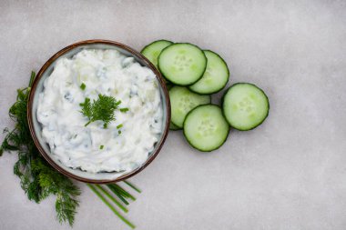 Taze Yunan yemeği, salatalık, yoğurt ve ottan yapılmış Tzatziki. Benekli gri bir yüzeyde kopyalama alanı