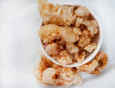 Kıtır kıtır, domuz derisi ya da fotokopi alanı olan beyaz kâsede çıtırdıyor.