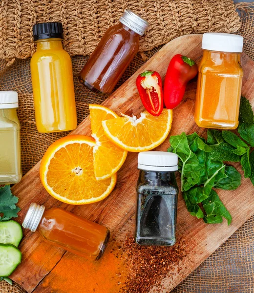 Juice shots for a healthy lifestyle, flat lay on rustic surface with ingredients