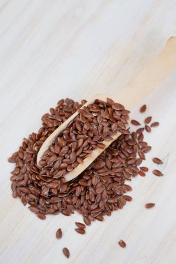 scoop of flax seeds on light wood