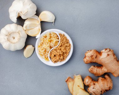 garlic and ginger, whole and crushed flat lay on grey. 