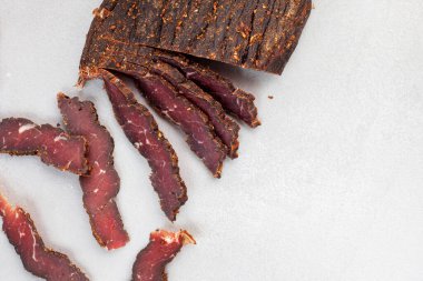 Freshly cut South African biltong on light background with selective focus and copy space