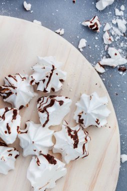white meringues drizzled with dark chocolate on gray with selective focus